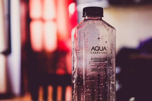 Detailed view of an Aqua Carpatica water bottle with droplets and blurred background.