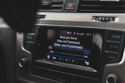 Close-up of car touchscreen displaying music with user interface mid-play